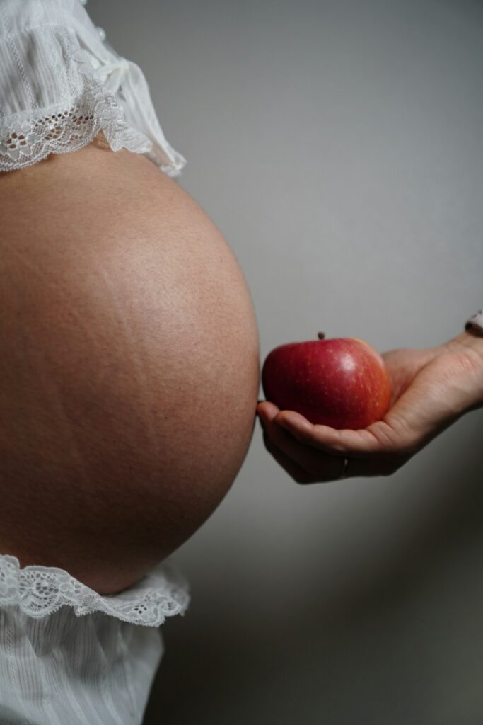 First trimester diet plan with a pregnant belly and fresh apple